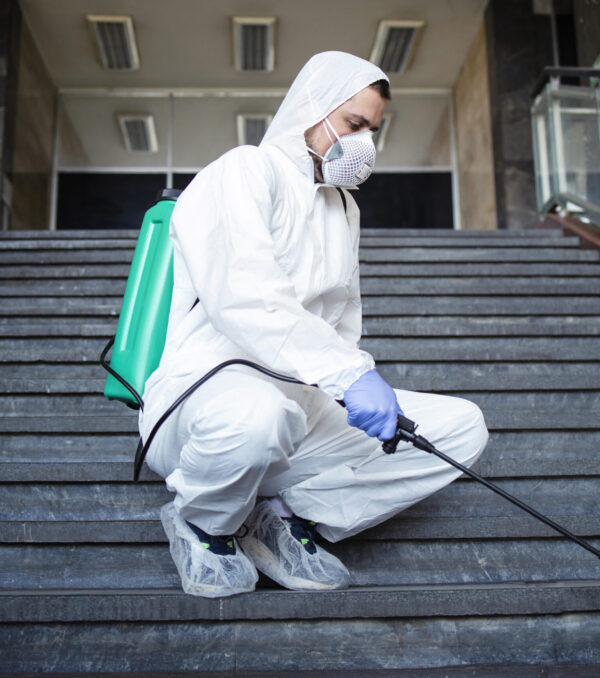 Person in white chemical protection suit disinfecting public corridors and steps to stop spreading highly contagious corona virus. Person in white chemical protection suit disinfecting public corridors and steps to stop spreading highly contagious corona virus.