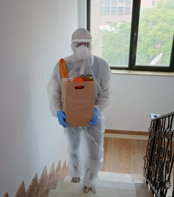 Volunteer delivering food order Volunteer delivering food order wearing coverall suit in covid-19 pandemic.